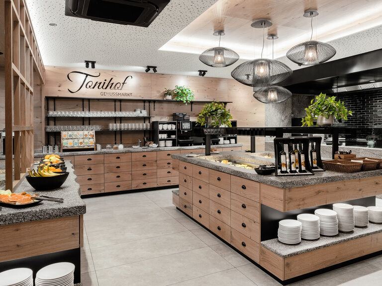 Das stilvoll gestaltete, hölzerne Frühstücksbuffet des Tonihof präsentiert eine Auswahl köstlicher Speisen.