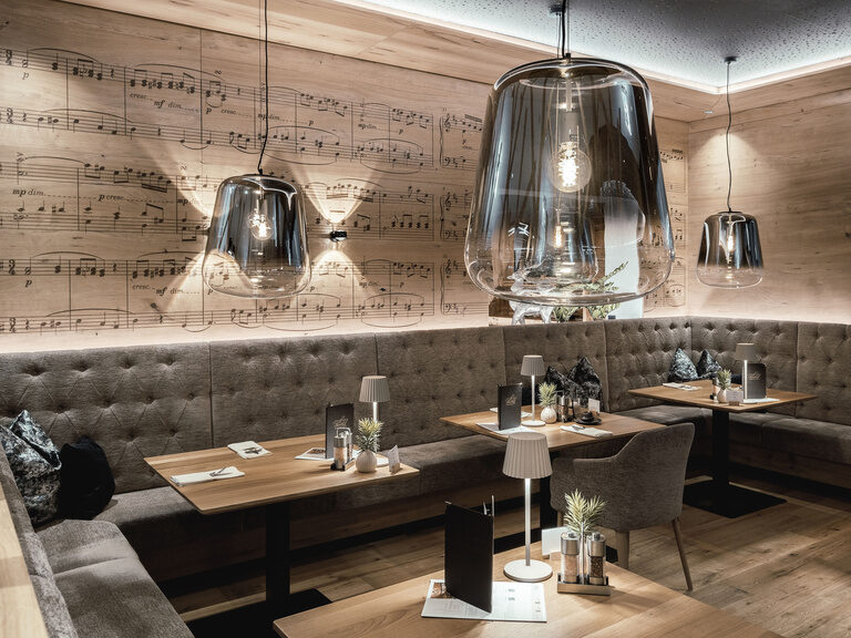 Im stilvoll eingerichteten Restaurant des Tonihofs im Bayerischen Wald schaffen sanfte Beleuchtung und bequeme Sitzplätze eine einladende Atmosphäre.